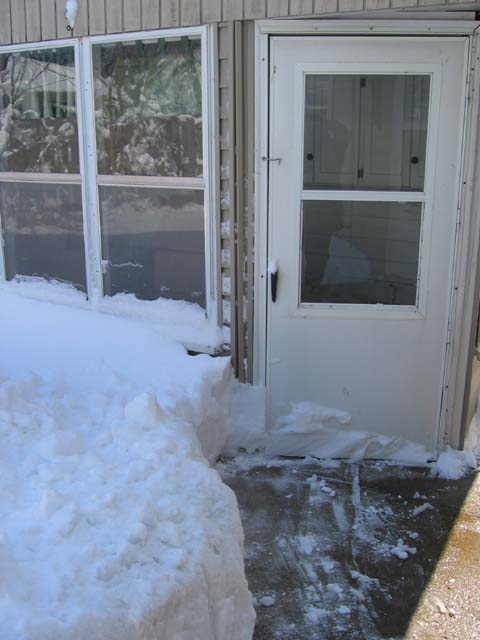 Snow up against the back porch